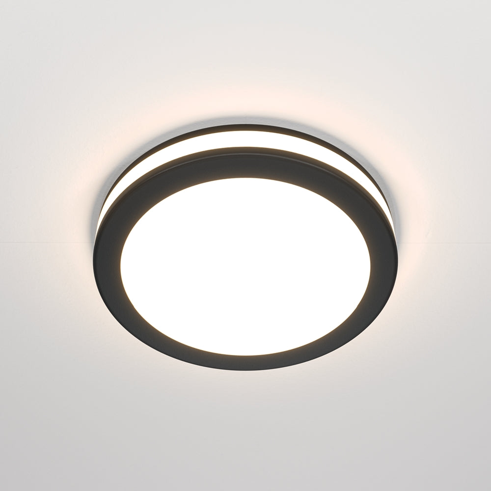 Spot rond noir encastré au plafond, diffuseur blanc allumé vu de face
