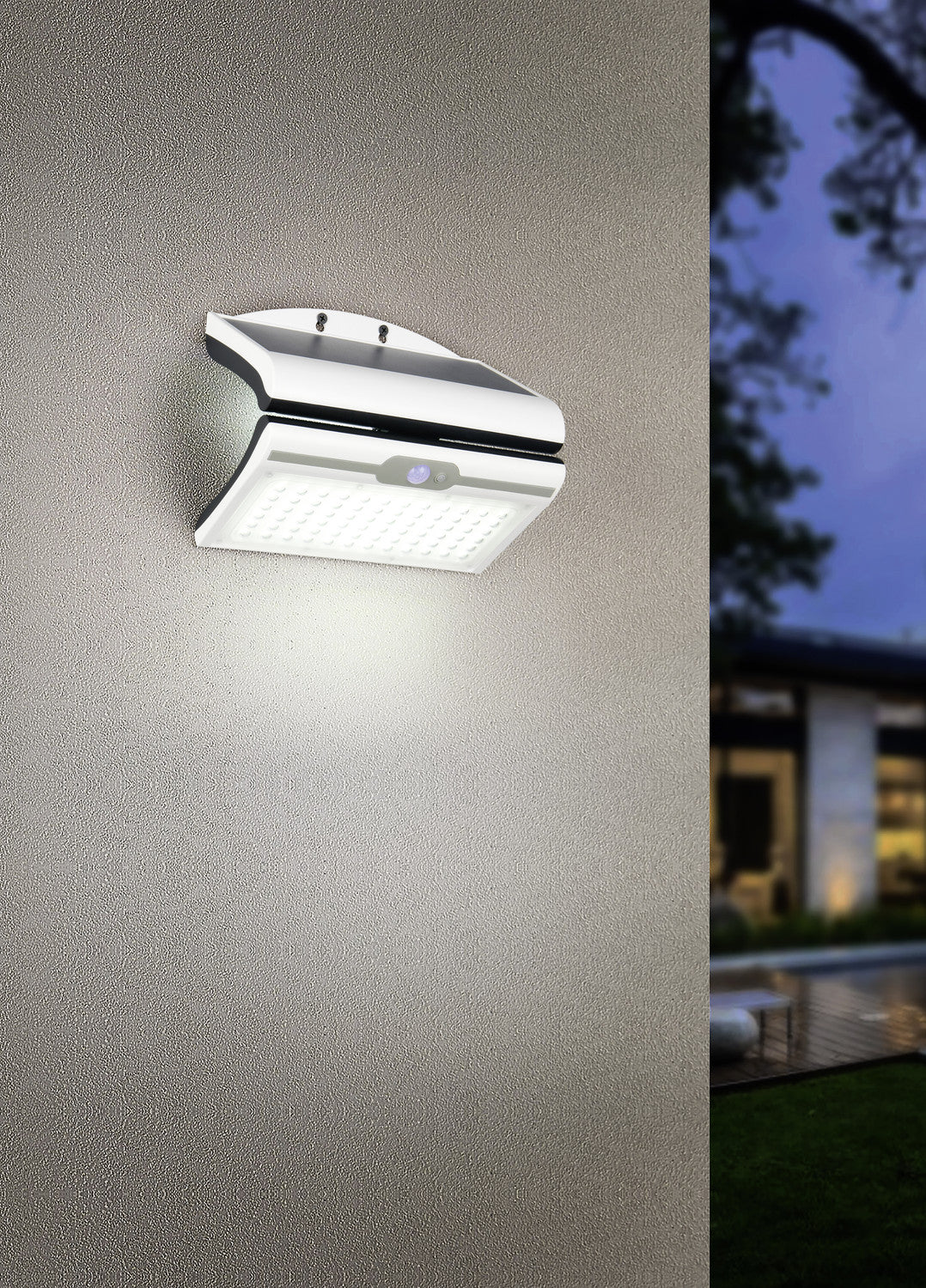Mise en ambiance nocturne sur un mur crépi, le luminaire éclaire vers le sol.