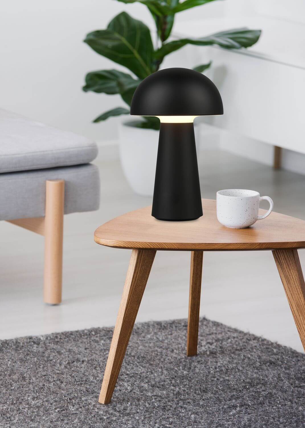 Vue rapprochée de la lampe allumée sur la table, intérieur clair et végétal
