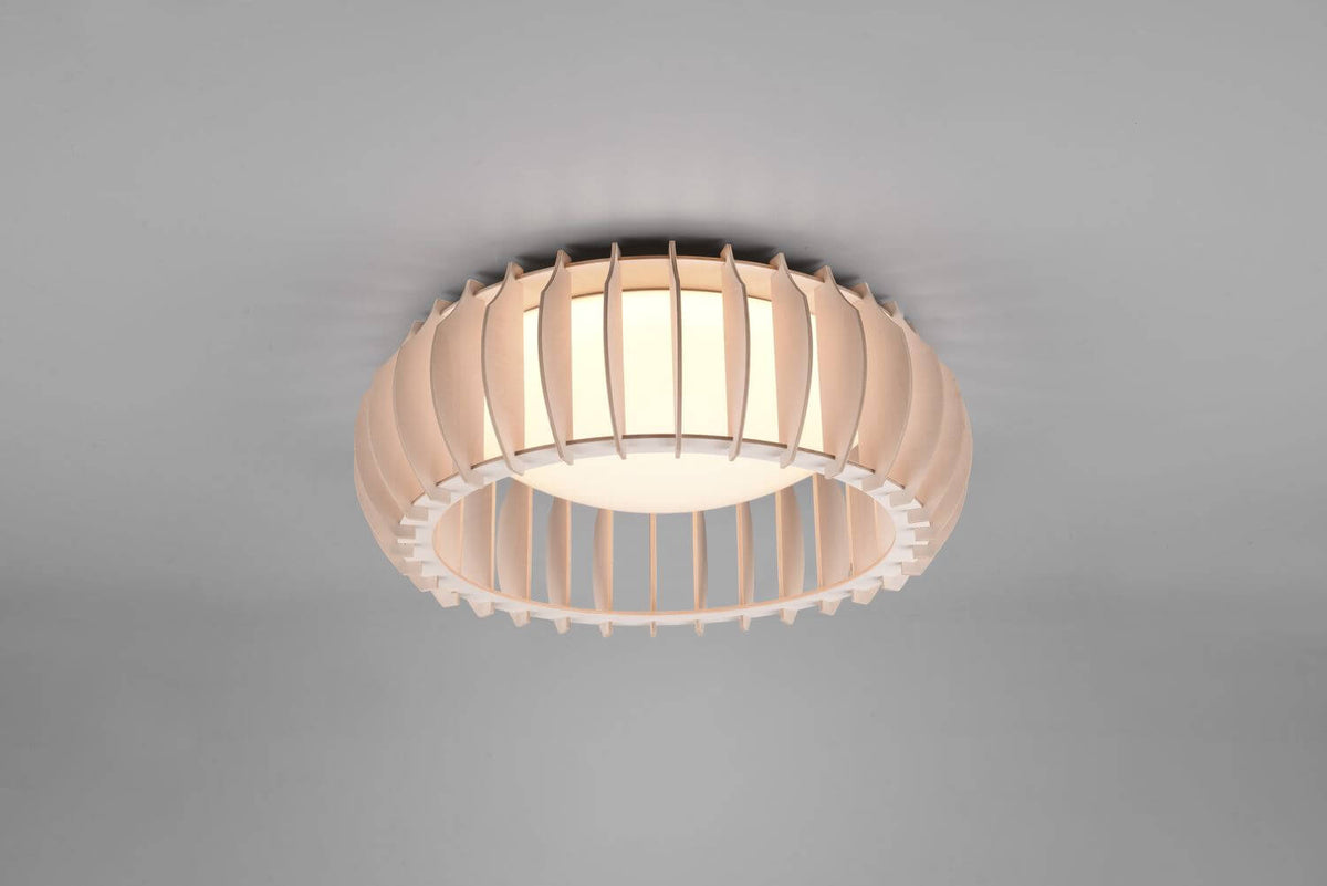 Vue rapprochée du plafonnier allumé, lamelles verticales courbes et diffuseur central lumineux