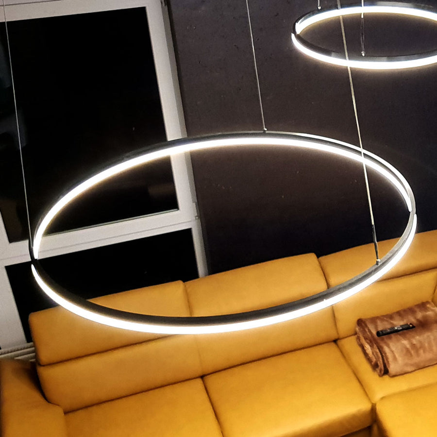 Détail de l'anneau allumé en lumière blanche au-dessus d'un canapé jaune