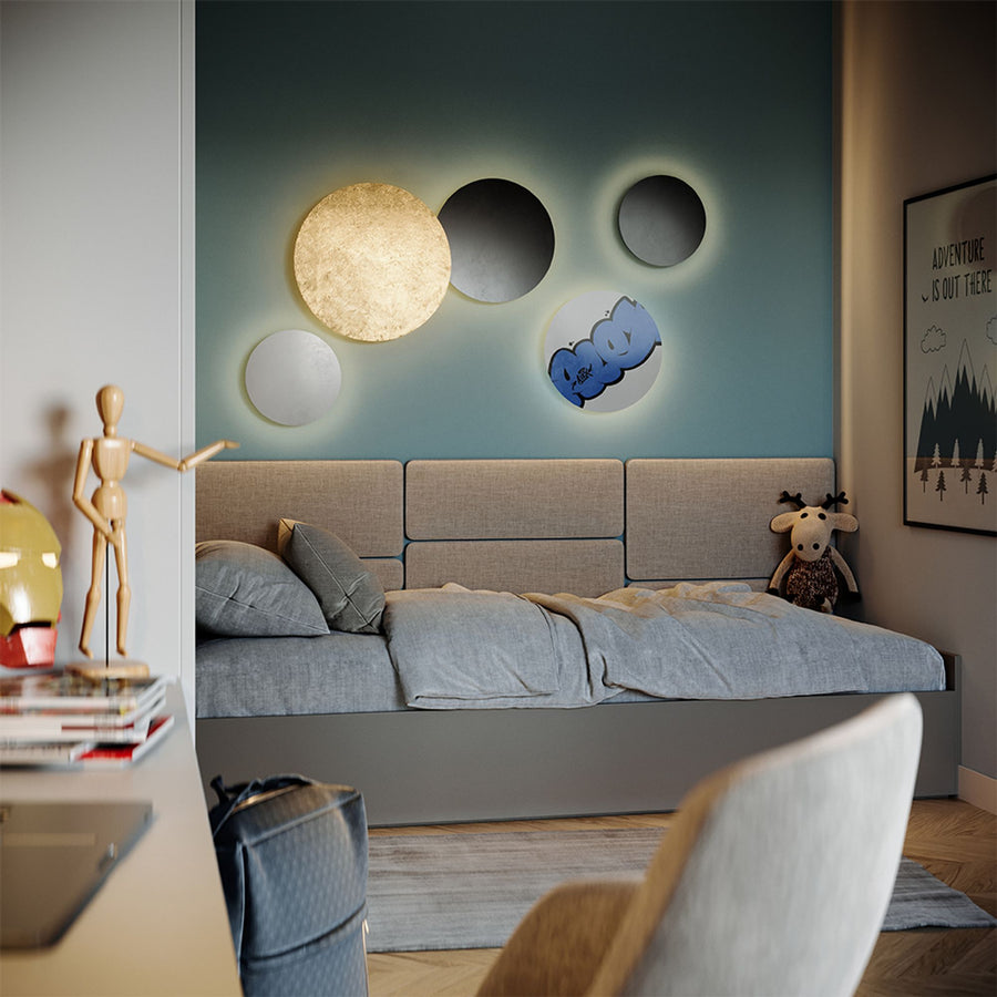 Chambre bleue avec disques muraux lumineux au-dessus du lit et personnage articulé.