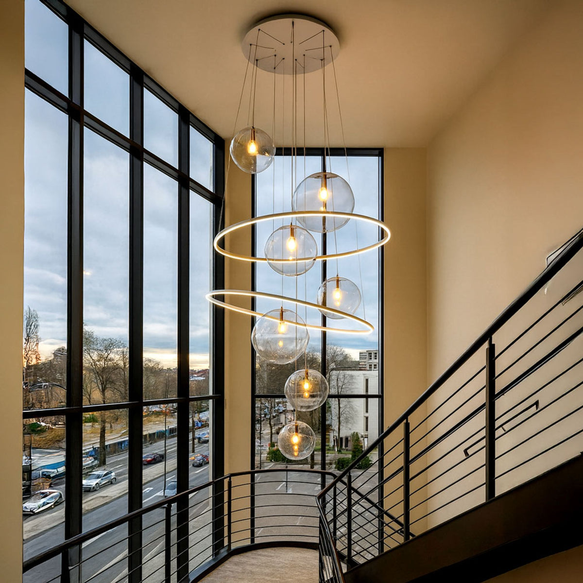 Suspension installée dans une cage d'escalier vitrée, vue de face avec globes et anneaux