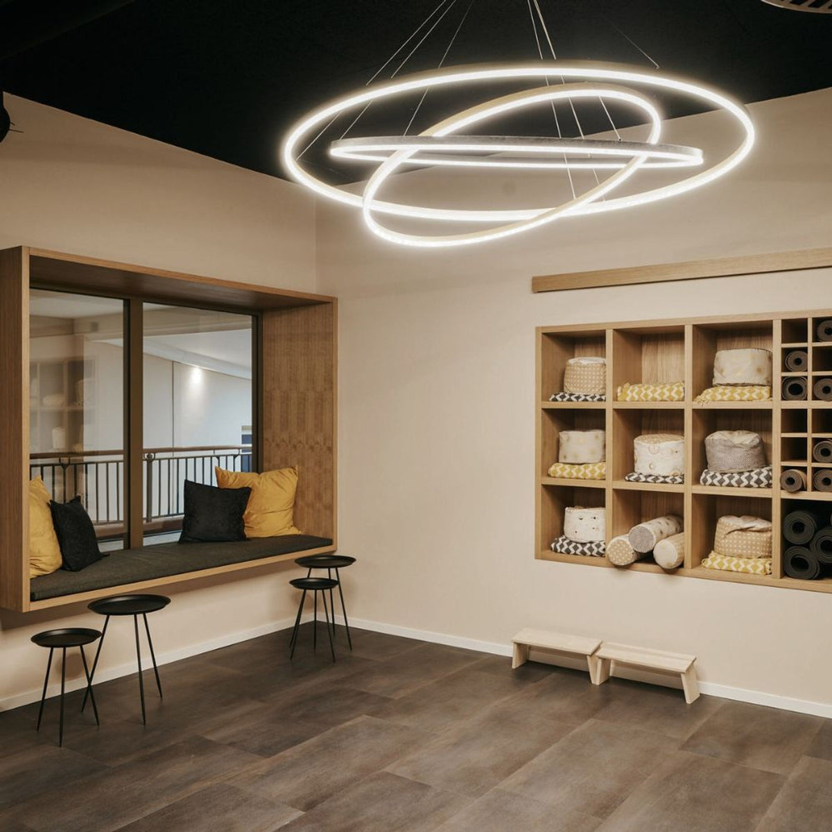 Mise en ambiance dans une salle de yoga, anneaux lumineux sous plafond noir