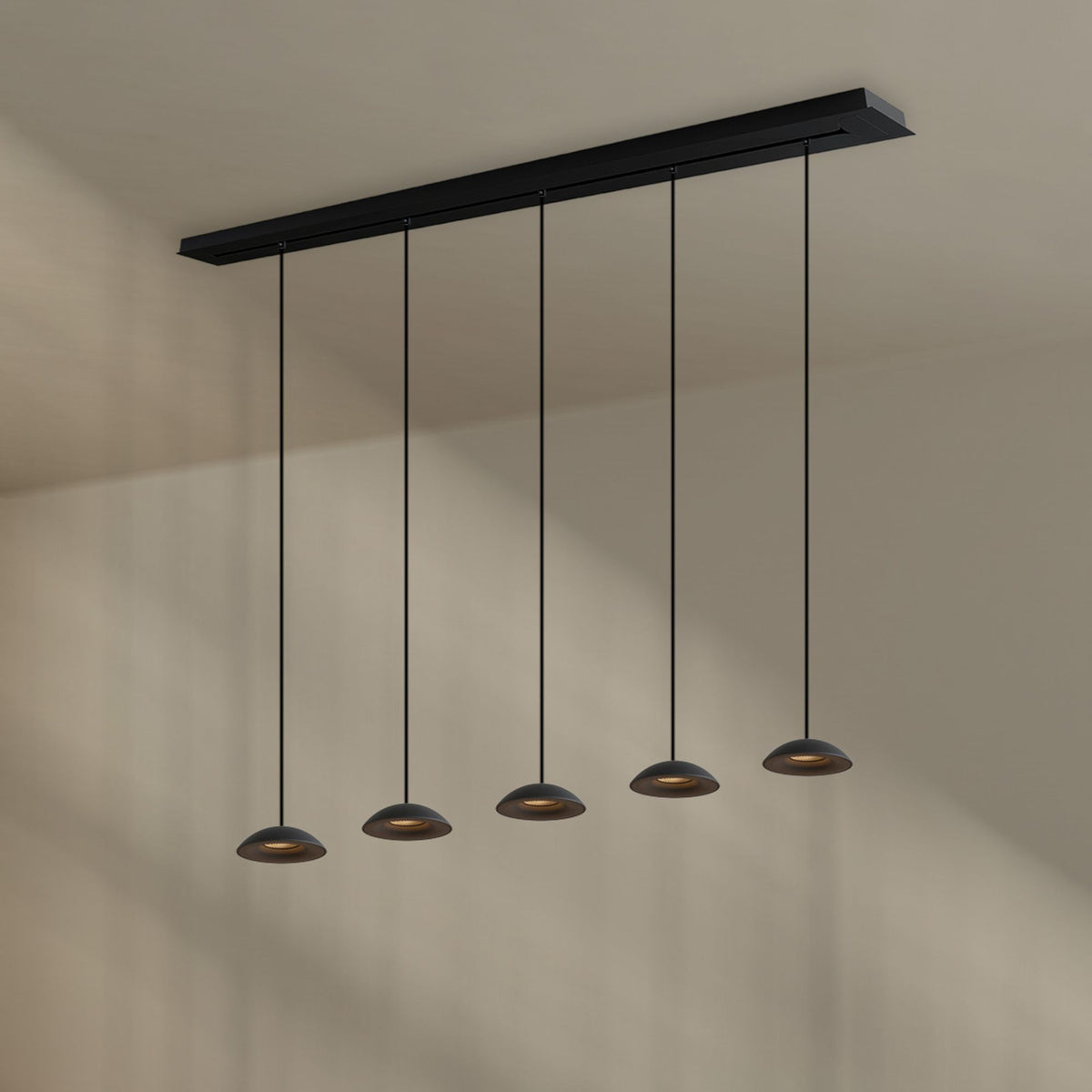 Vue de dessous du luminaire noir fixé au plafond avec cinq abat-jours suspendus