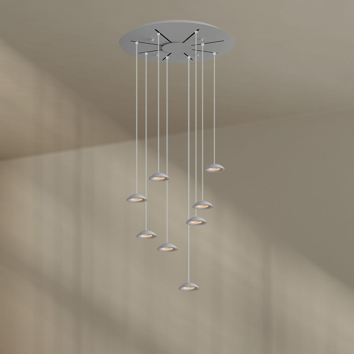 Version blanche de la suspension à huit lumières, câbles et rosace blancs, sur fond neutre.