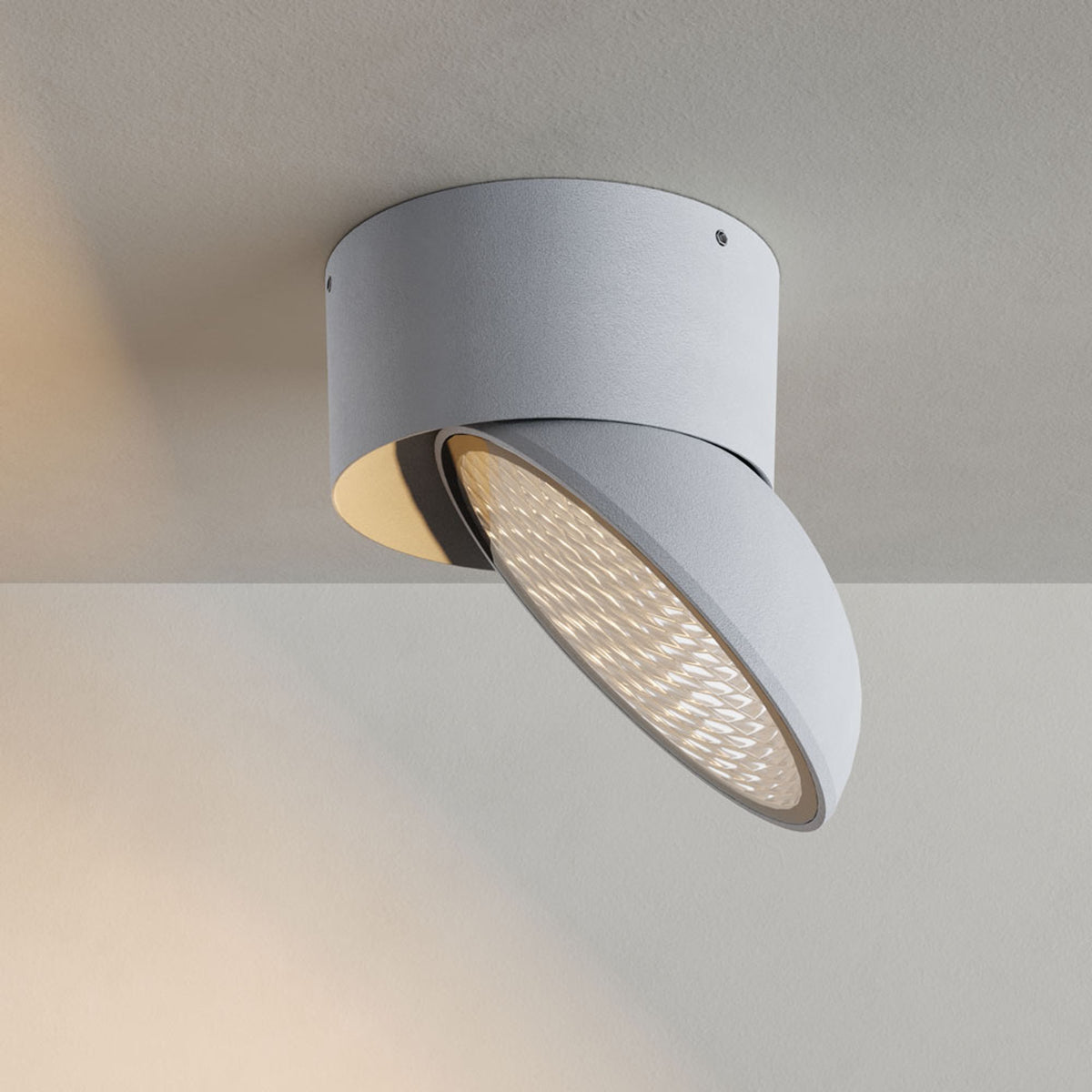 Vue de face du spot plafonnier blanc orientable, diffuseur en verre strié allumé