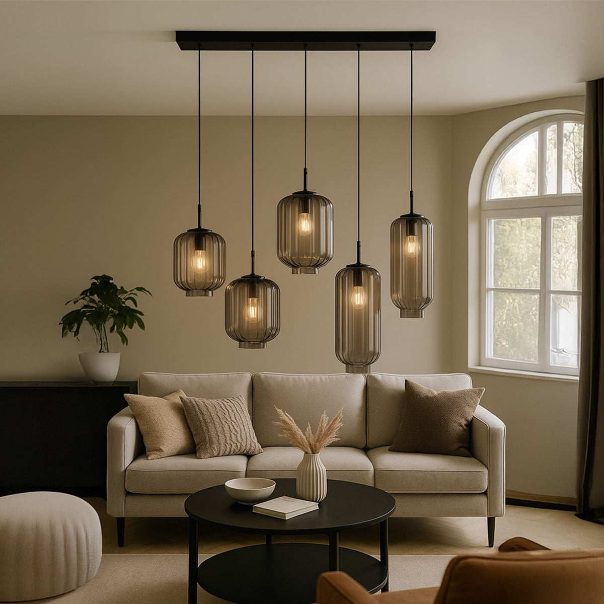Suspension cinq globes en verre fumé installée au-dessus d'une table basse dans un salon