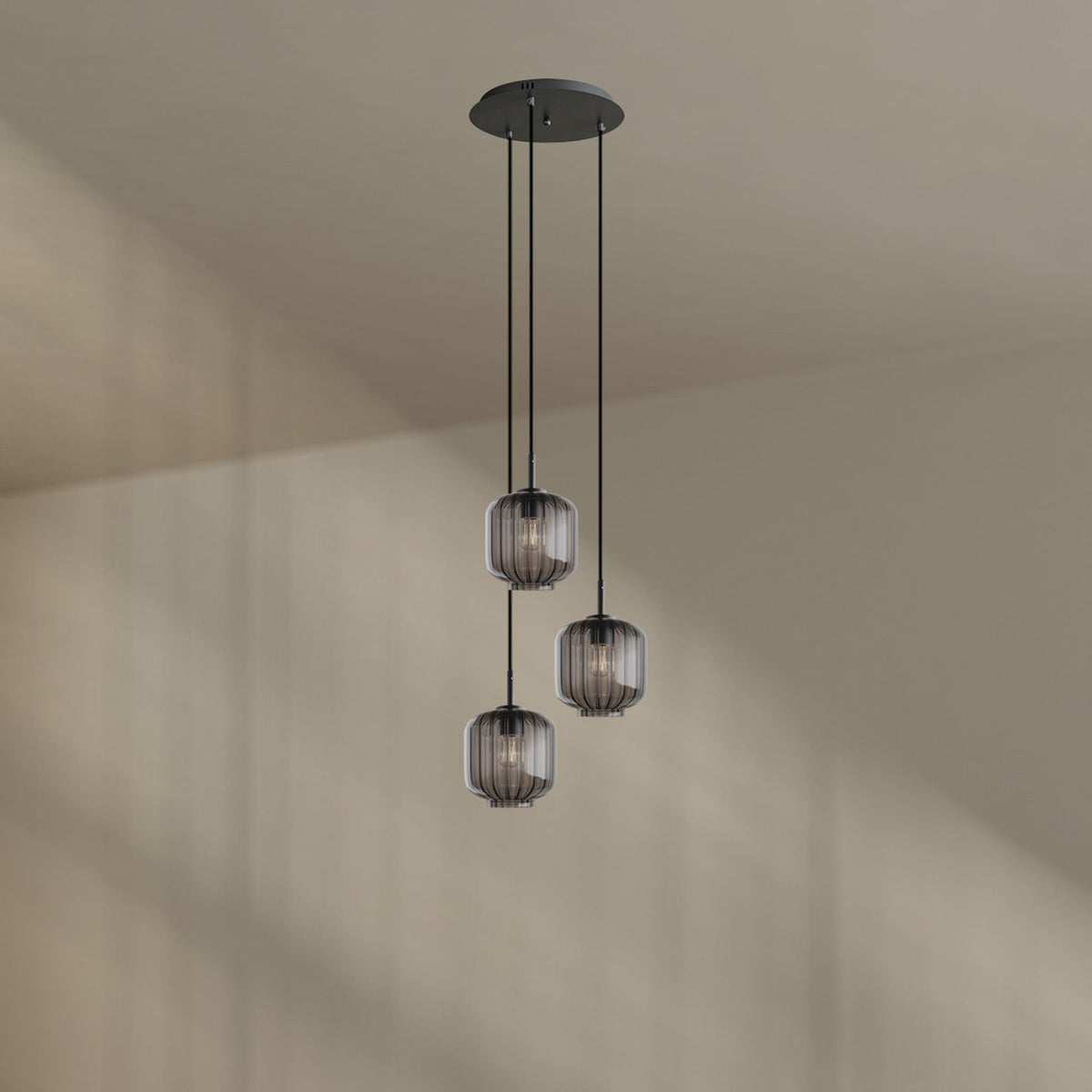 Suspension aux verres fumés gris clair suspendue devant un mur beige