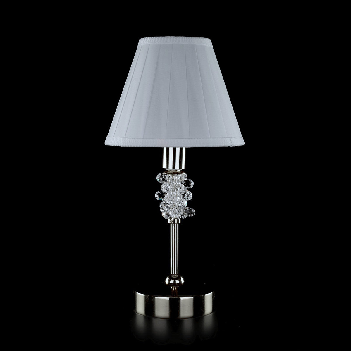 Lampe à poser chromée avec abat-jour conique plissé blanc, vue de face sur fond noir.