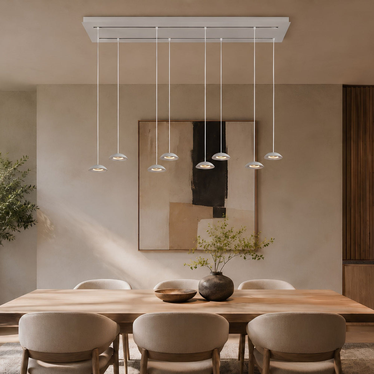 Suspension blanche à huit lumières au-dessus d'une table à manger en bois clair