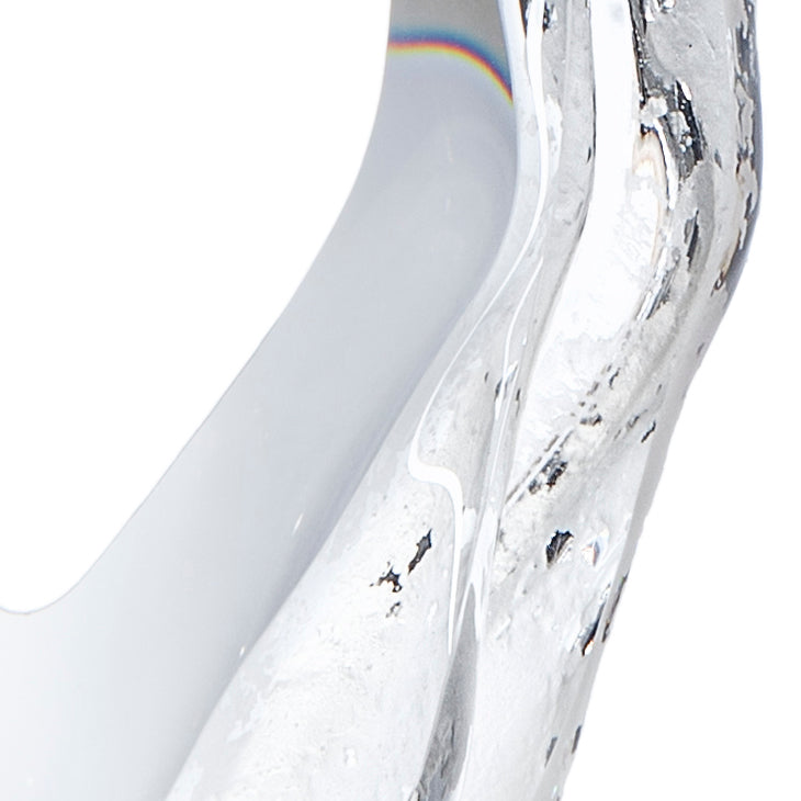 Détail du bord de la pièce en verre avec reflets irisés sur fond clair