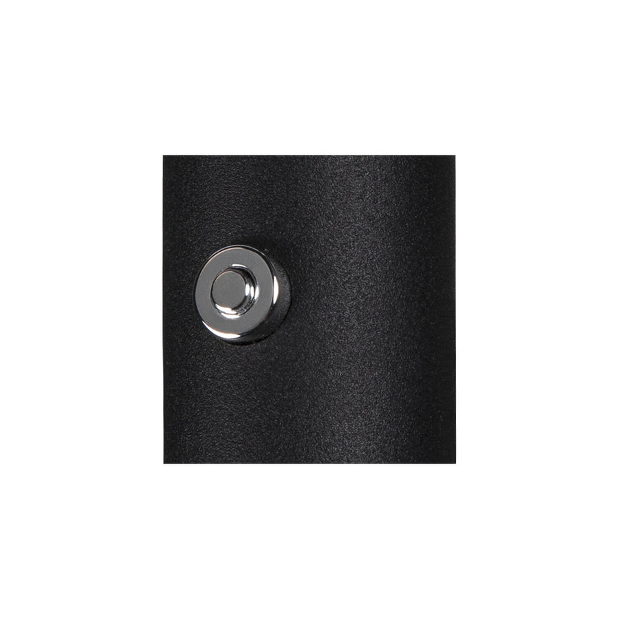 Détail du bouton-poussoir chromé sur la surface noire texturée de l’applique.