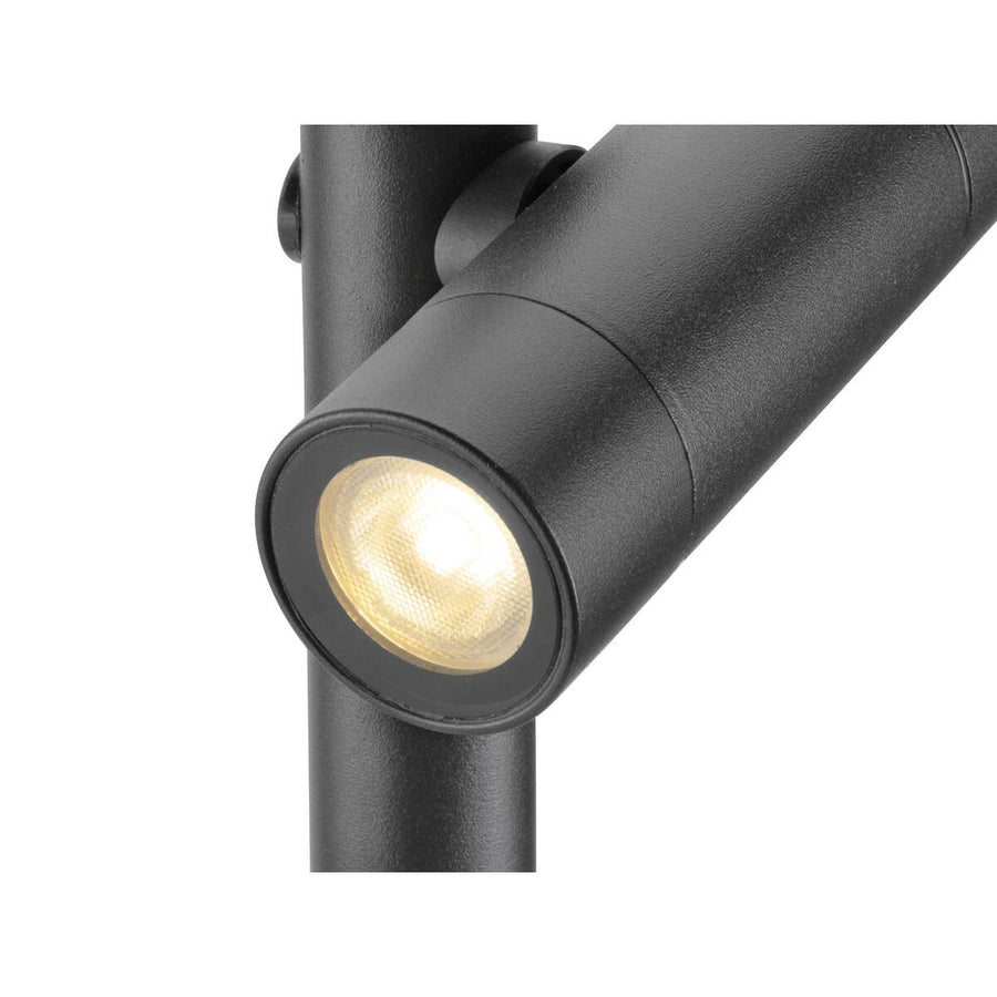Détail rapproché d’une tête de projecteur noire texturée et de sa lentille LED allumée.