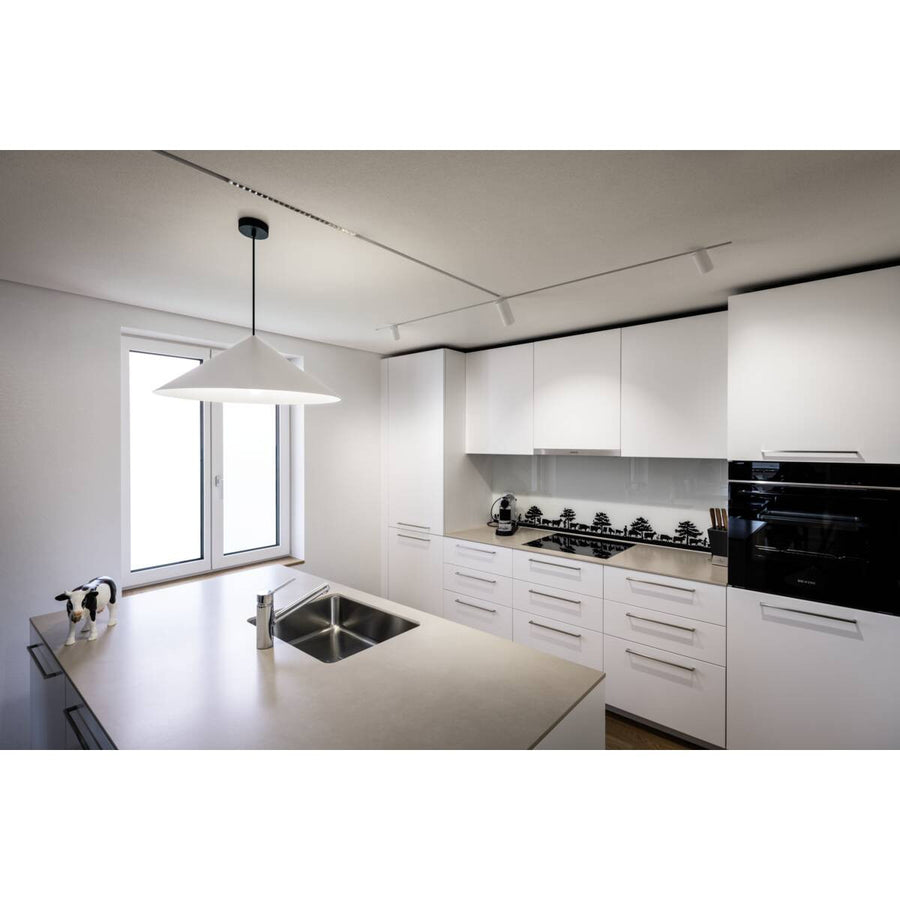 Suspension blanche installée au-dessus d'un îlot de cuisine moderne blanc.