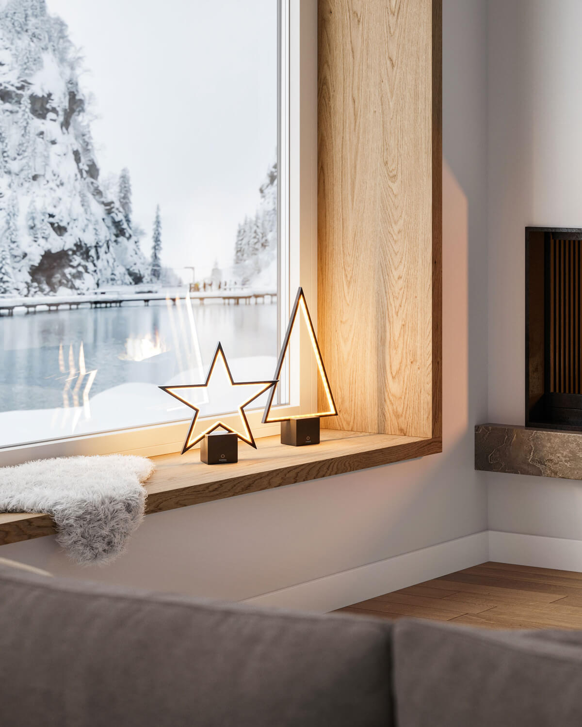 Mise en ambiance intérieure : lampe étoile et sapin sur rebord, canapé et cheminée.