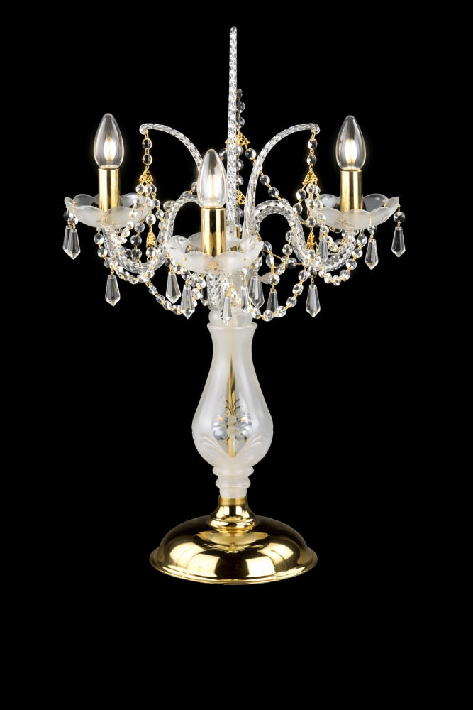 Même lampe allumée, ampoules visibles, pampilles de cristal et base dorée brillante