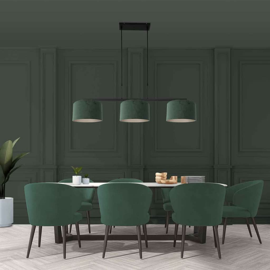 Mise en ambiance dans une salle à manger verte, suspension allumée au-dessus d'une table.