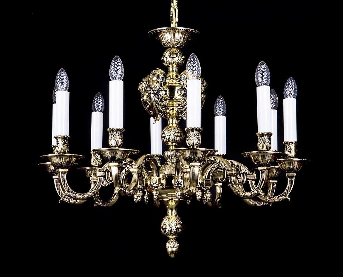 Lustre en laiton doré à dix bras, bougies blanches et ampoules cristal, sur fond noir