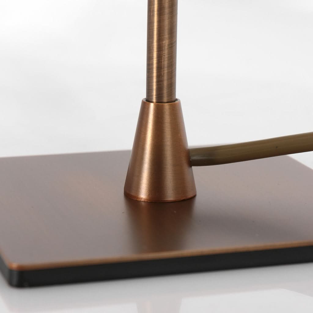 Gros plan du pied carré et de la tige en bronze, avec cordon apparent.