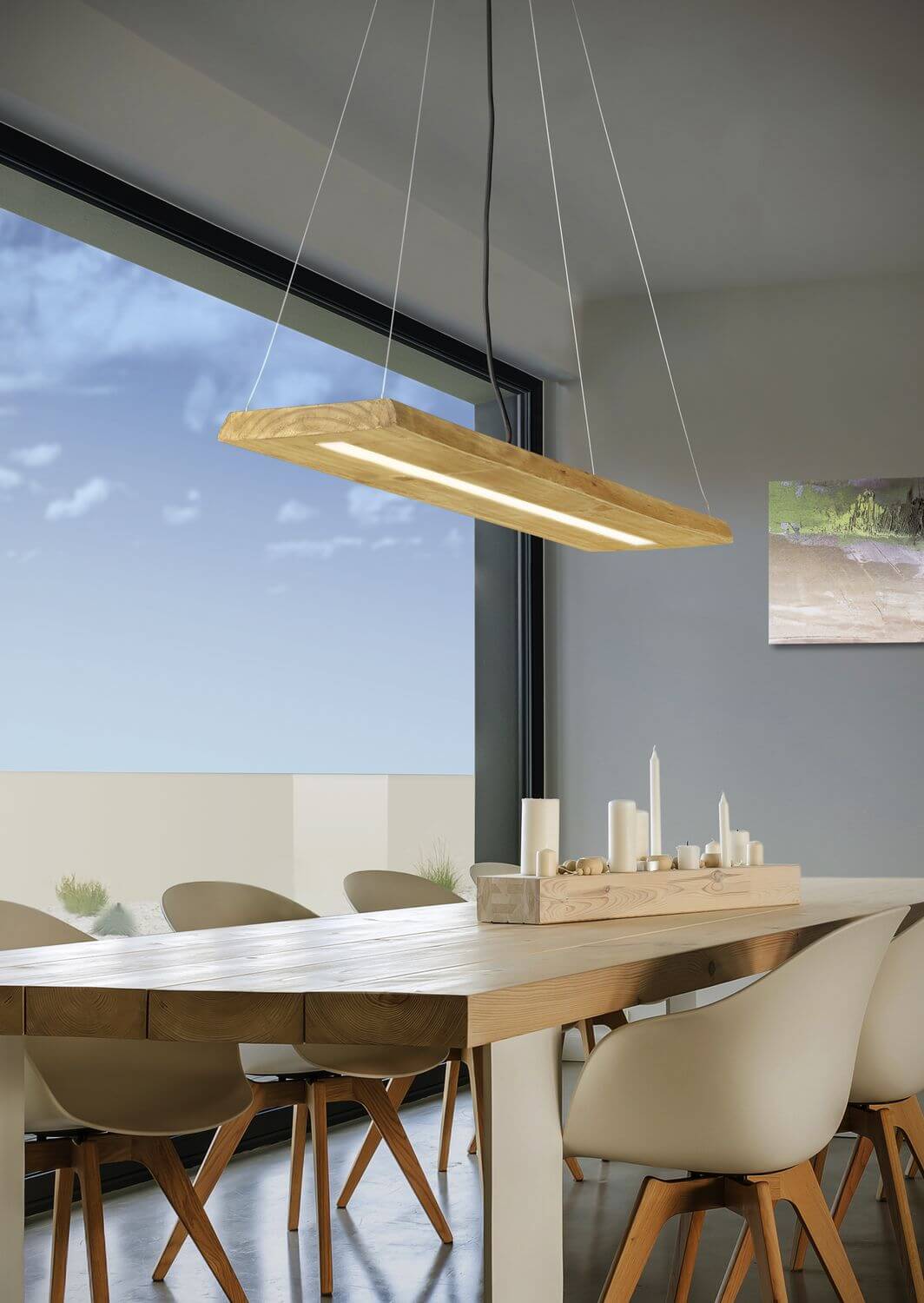 Mise en ambiance avec baie vitrée, le luminaire éclaire la table et les chaises.