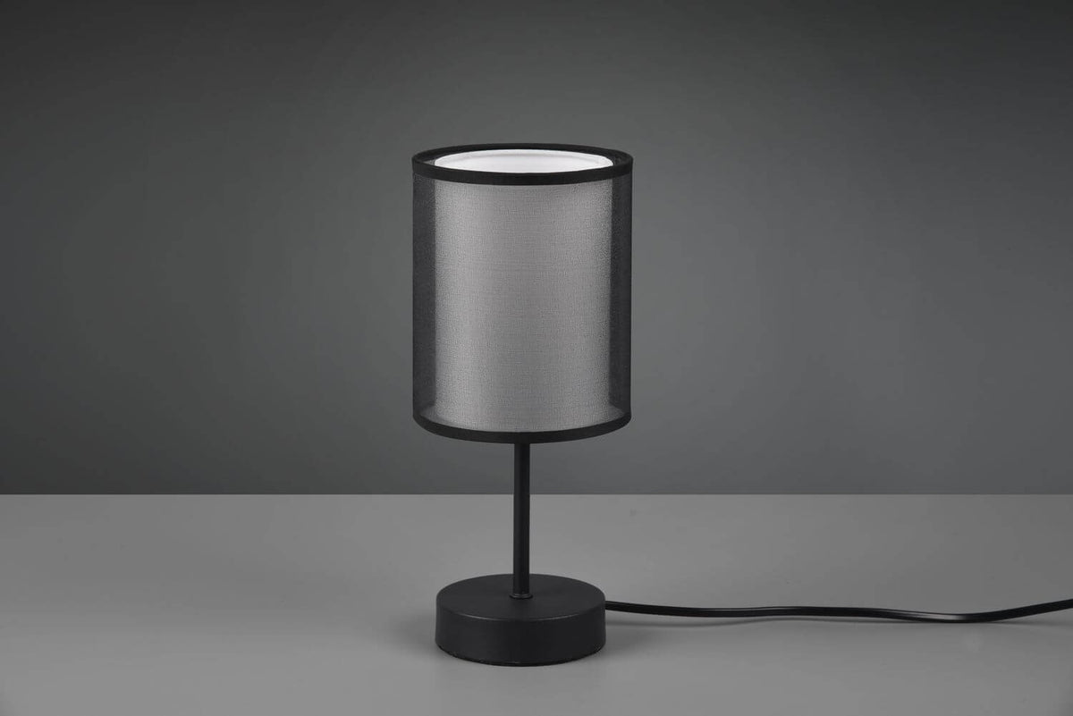 Luminaire éteint sur fond gris, détail de l'abat-jour en tissu et du socle