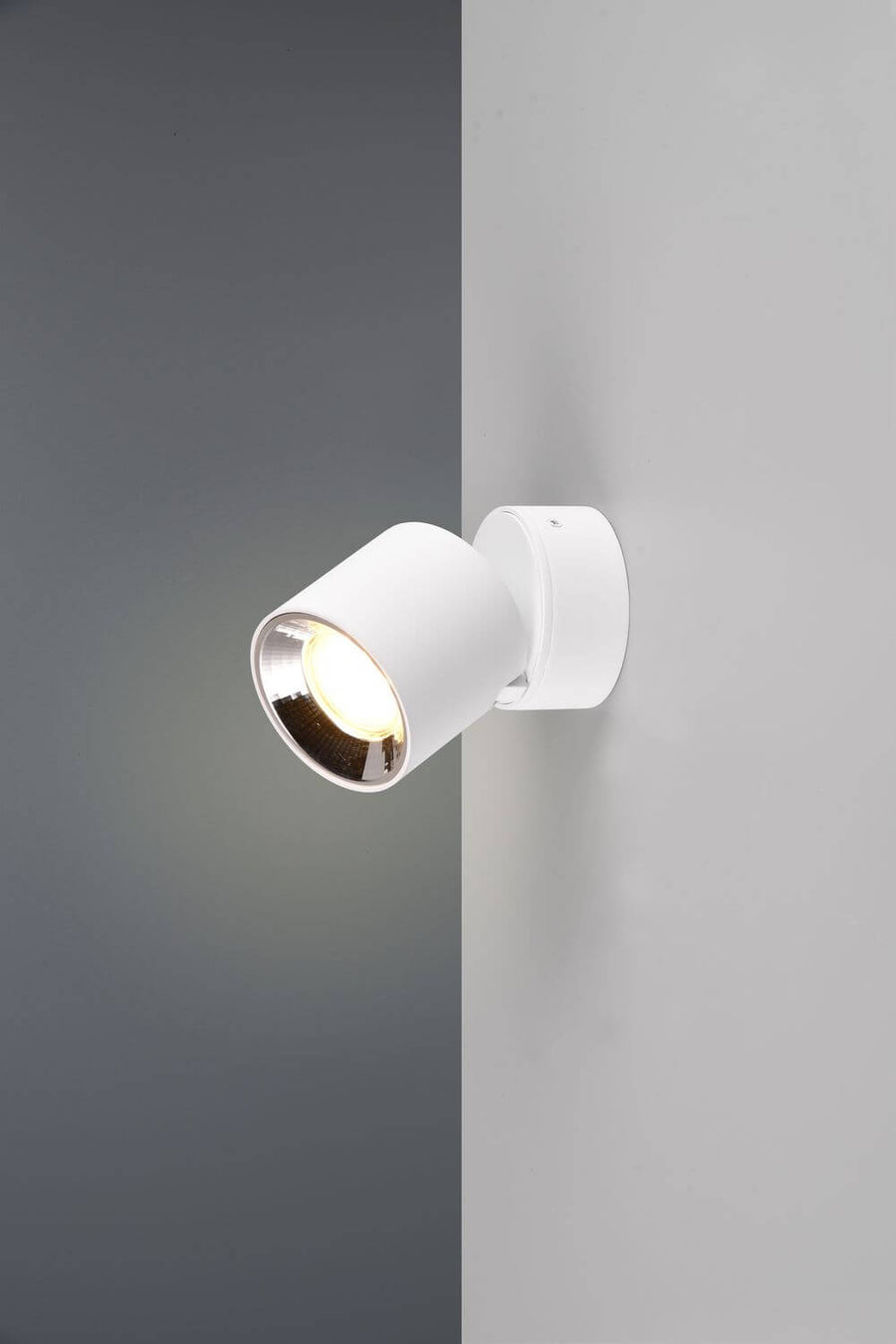 Gros plan sur le projecteur blanc et son réflecteur chromé orientable.