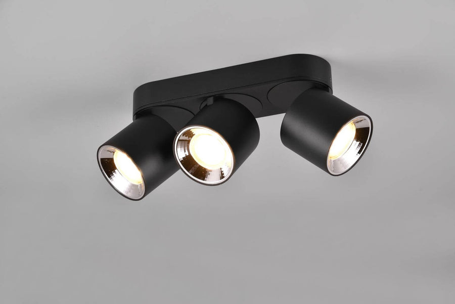 Vue rapprochée du plafonnier trois spots noirs orientables, intérieur réflecteur argenté.