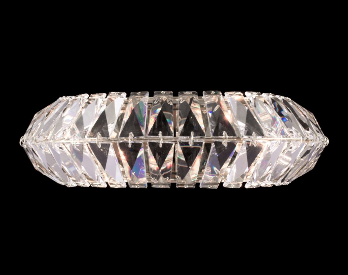 Vue de face de l'applique ovale, cristaux triangulaires facettés sur monture argentée brillante