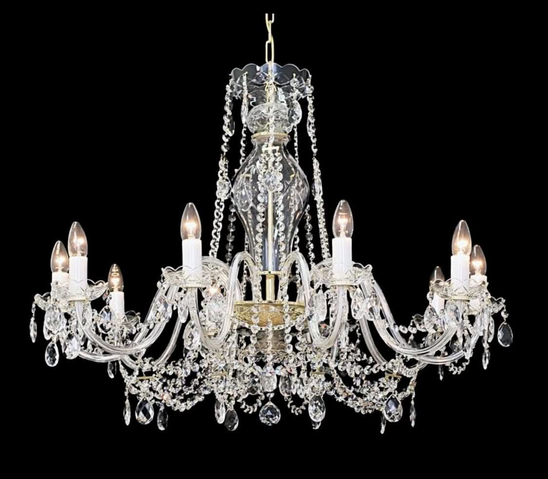 Lustre en cristal avec bras recourbés et pendeloques, présenté de face sur fond noir.