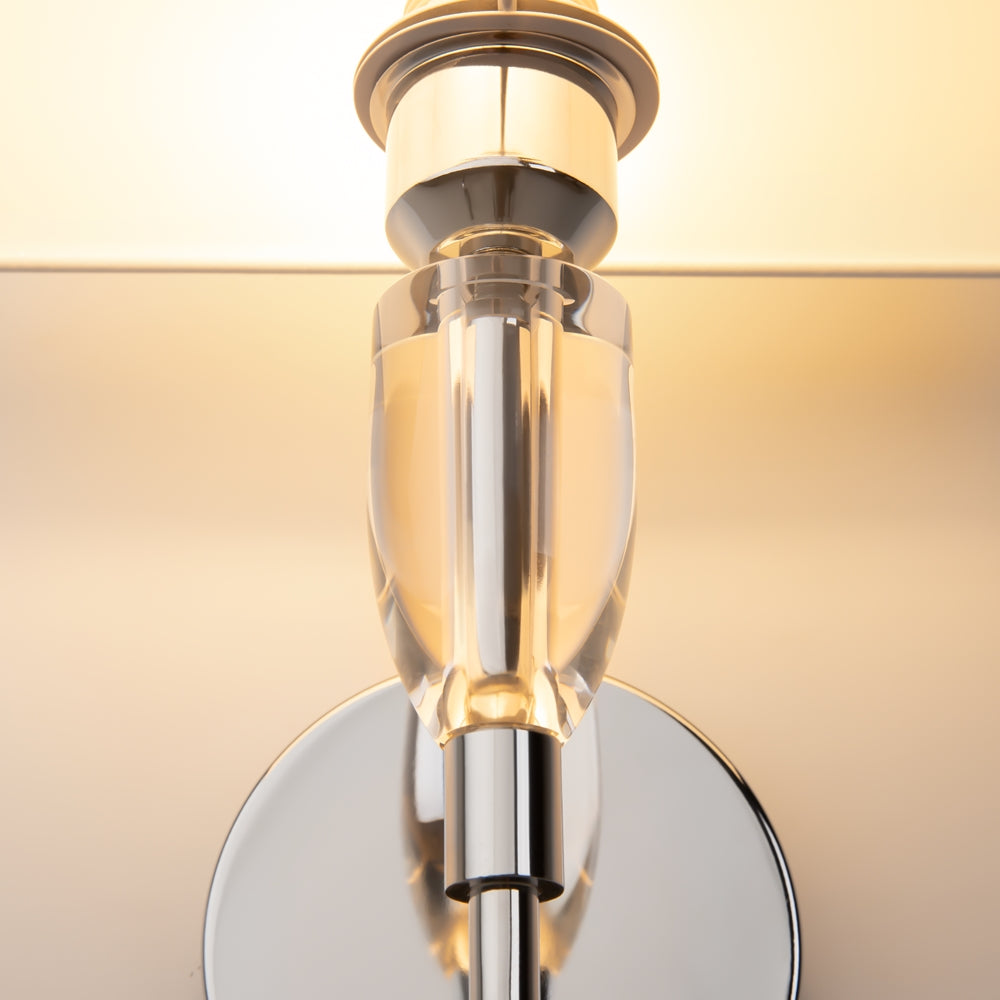 Détail de la jonction en verre transparent et métal chromé sous l'abat-jour.