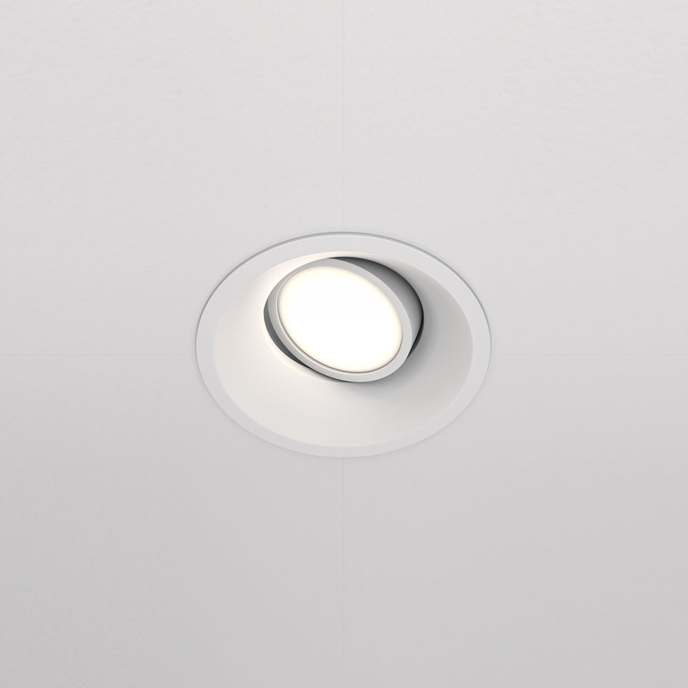 Spot rond blanc encastré dans un plafond, orienté vers le bas, vue de face