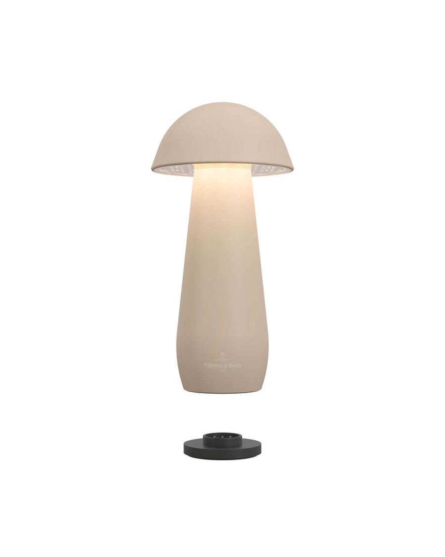 Vue éclatée de la lampe beige et de sa base de recharge noire séparée, éclairage allumé.