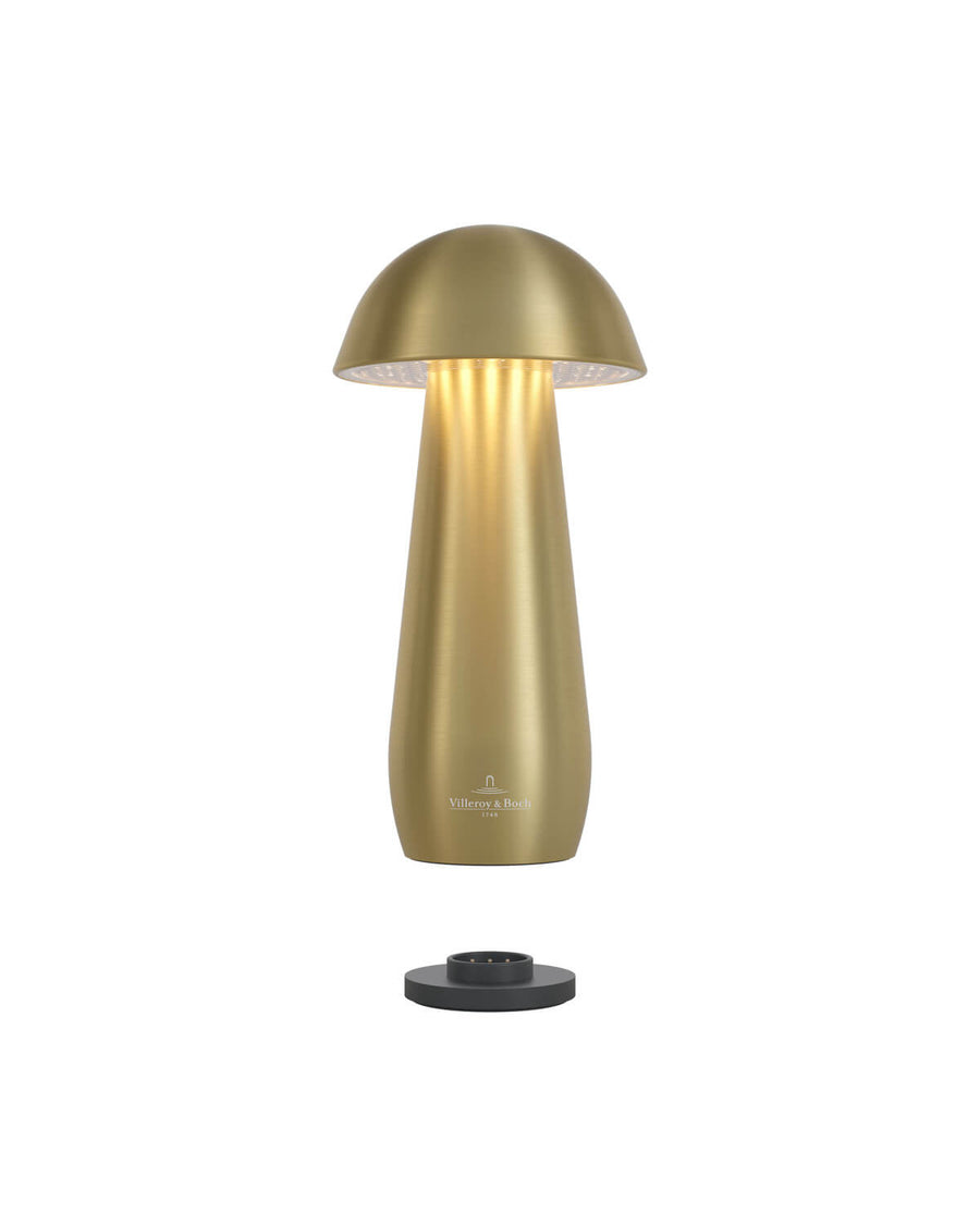 Lampe allumée au-dessus de son socle de recharge noir, lumière chaude