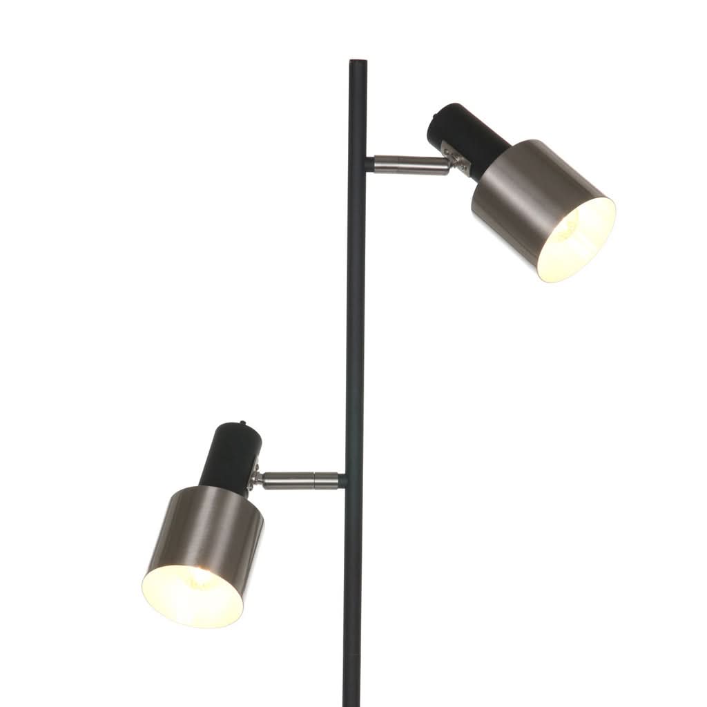 Détail des deux têtes orientables du lampadaire, projecteurs cylindriques noirs et métal brossé.
