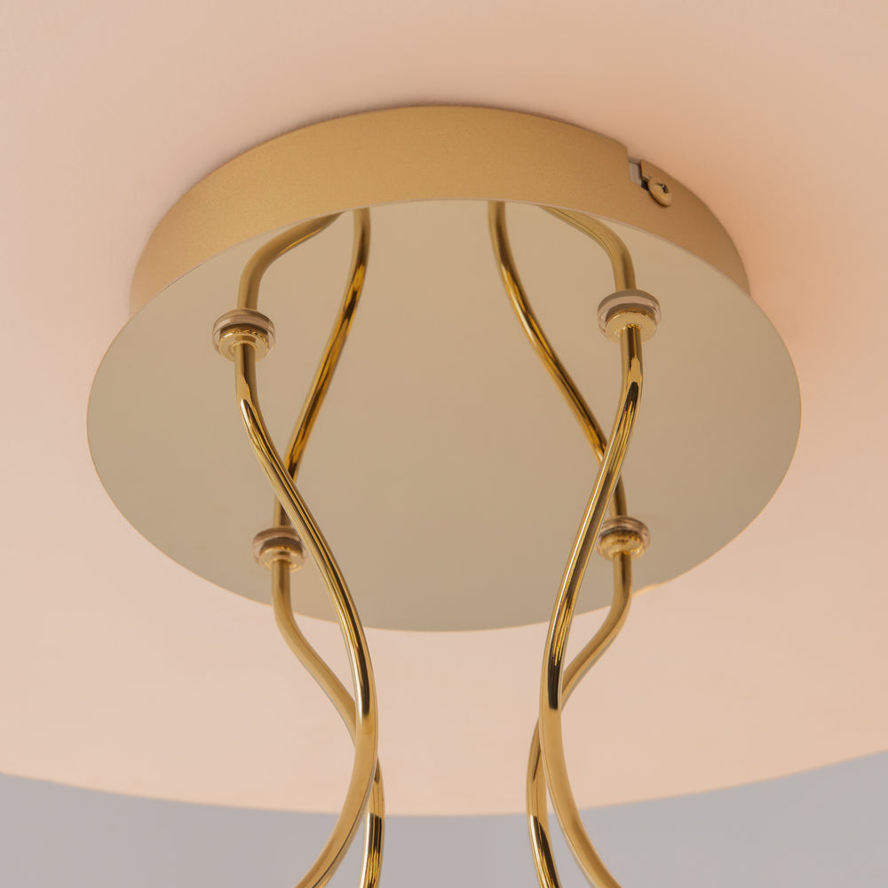 Détail de la base circulaire dorée fixée au plafond et de ses tiges