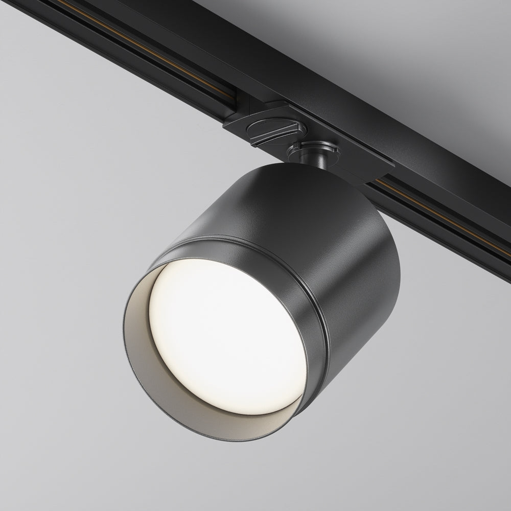Spot cylindrique noir fixé sur rail au plafond, vu de trois quarts