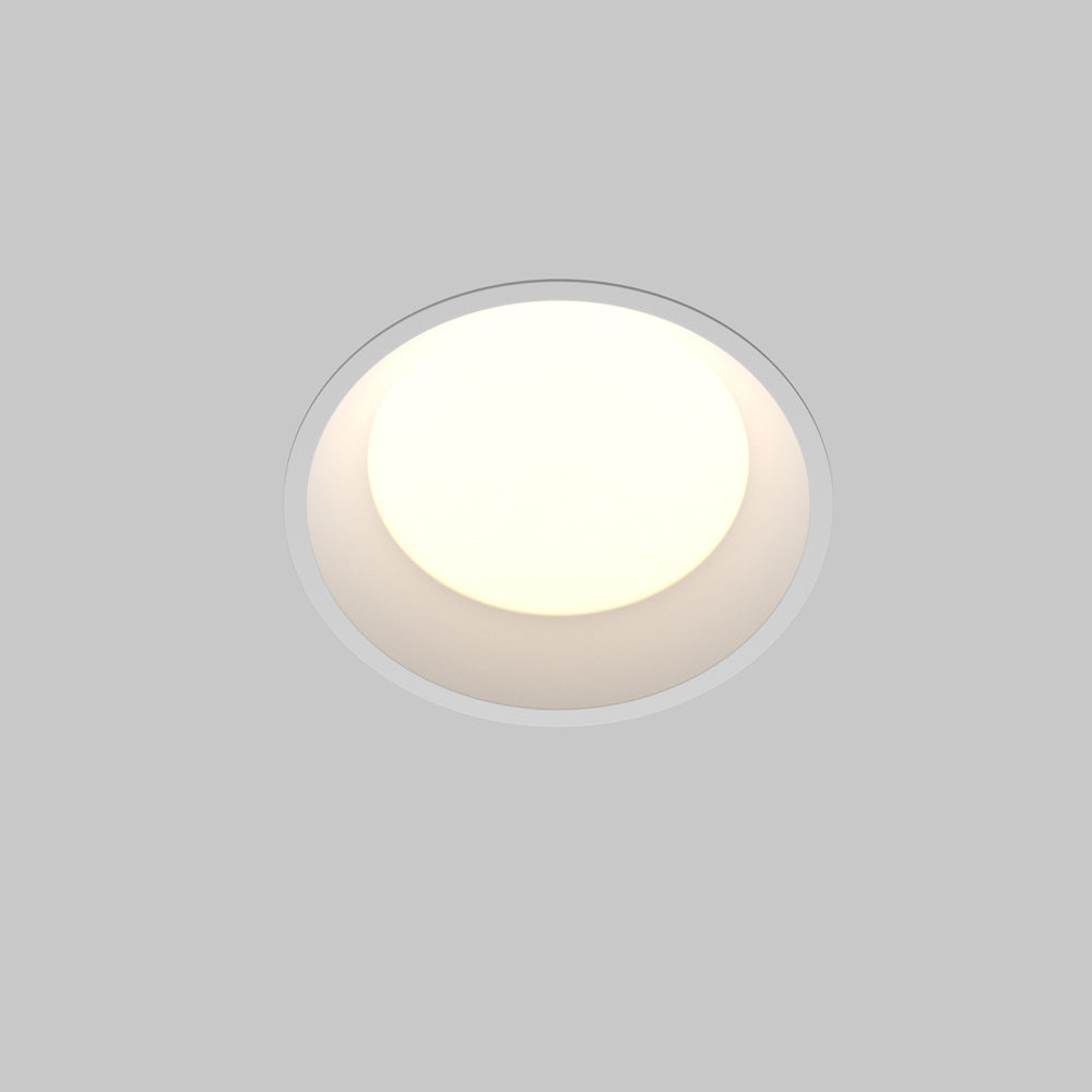 Spot encastré rond blanc vu de face, lumière chaude allumée sous plafond