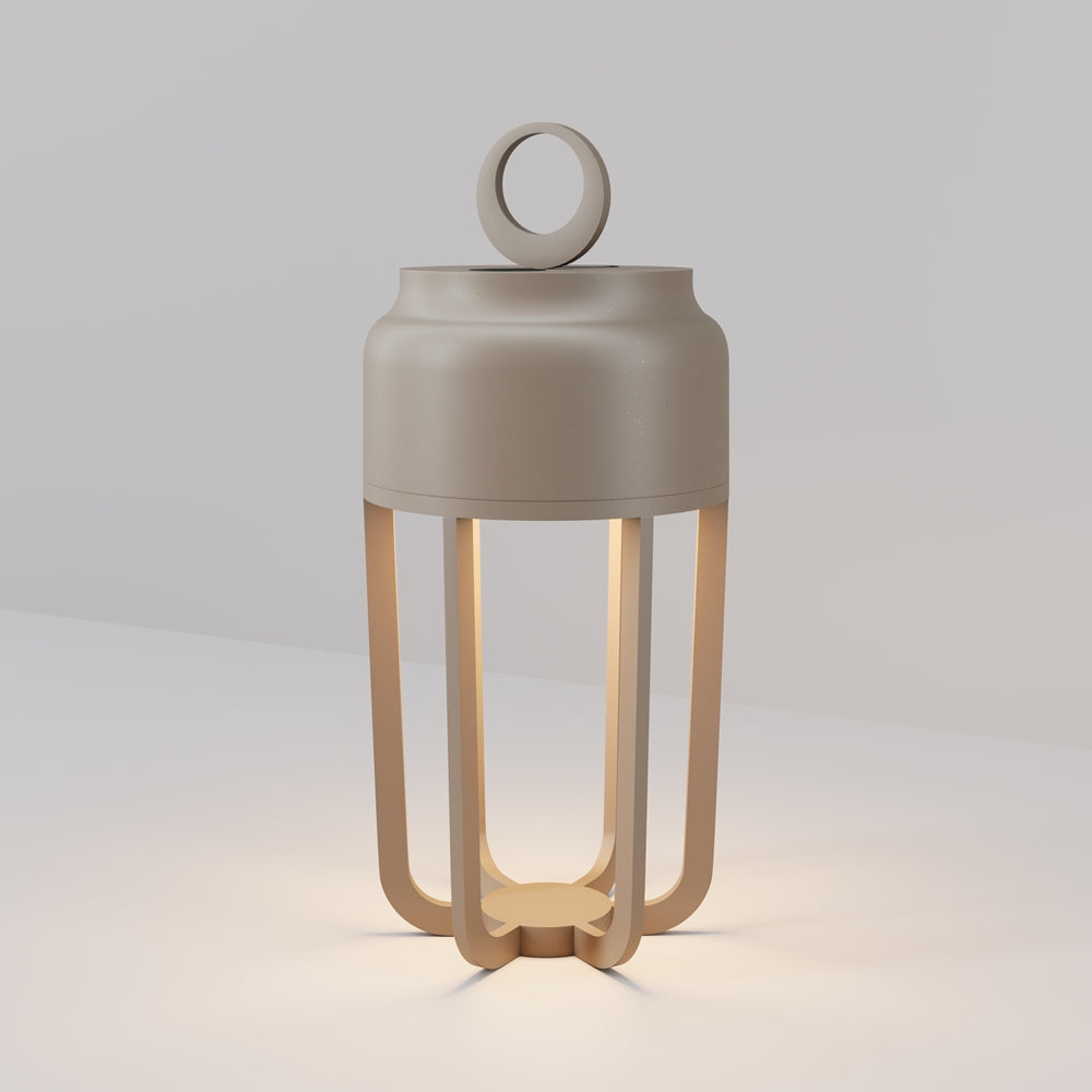 Luminaire beige de face, anse ronde et quatre pieds incurvés en lanterne