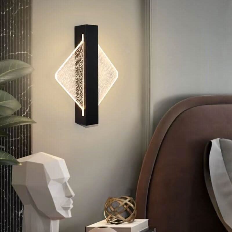 Version noire en losange fixée dans une chambre à tête de lit marron et plante.