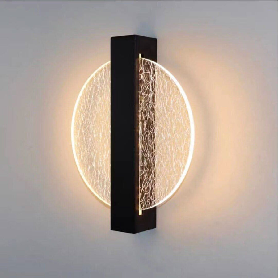Vue frontale nette du luminaire mural doré rond, fort contraste avec le fond.