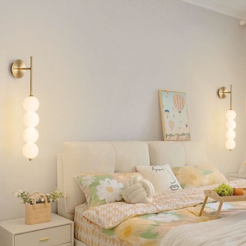 Deux appliques dorées identiques encadrant un lit, ambiance chambre cosy et symétrique