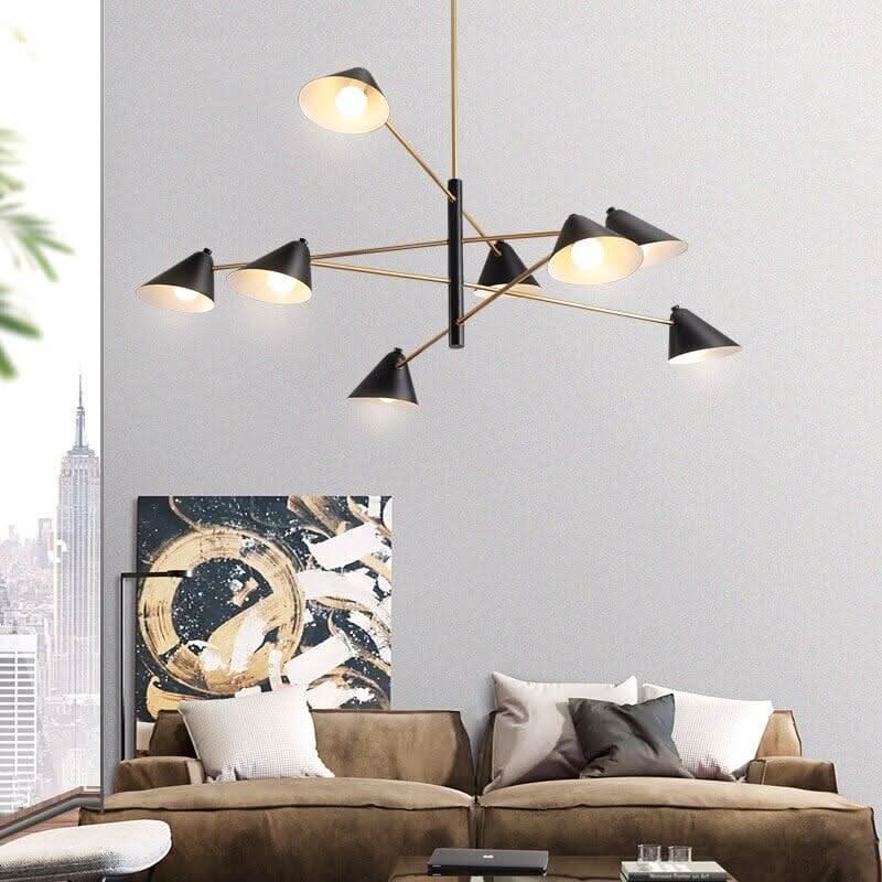 Vue en situation du luminaire au-dessus d'un canapé, avec toile et fenêtre urbaine.