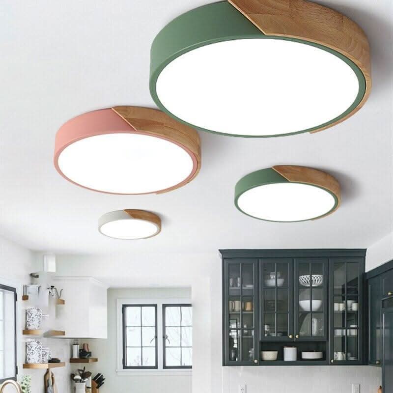Mise en ambiance de plusieurs plafonniers colorés dans une cuisine blanche à meubles vitrés