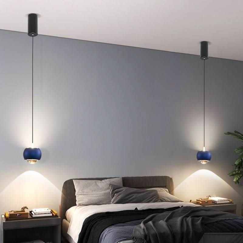 Paire de suspensions bleues suspendues devant un mur gris, lit gris en arrière-plan.