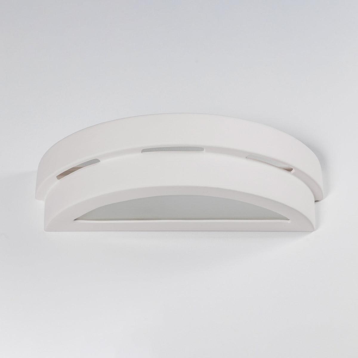 Vue de trois quarts du luminaire blanc, profil galbé et ouverture basse arrondie