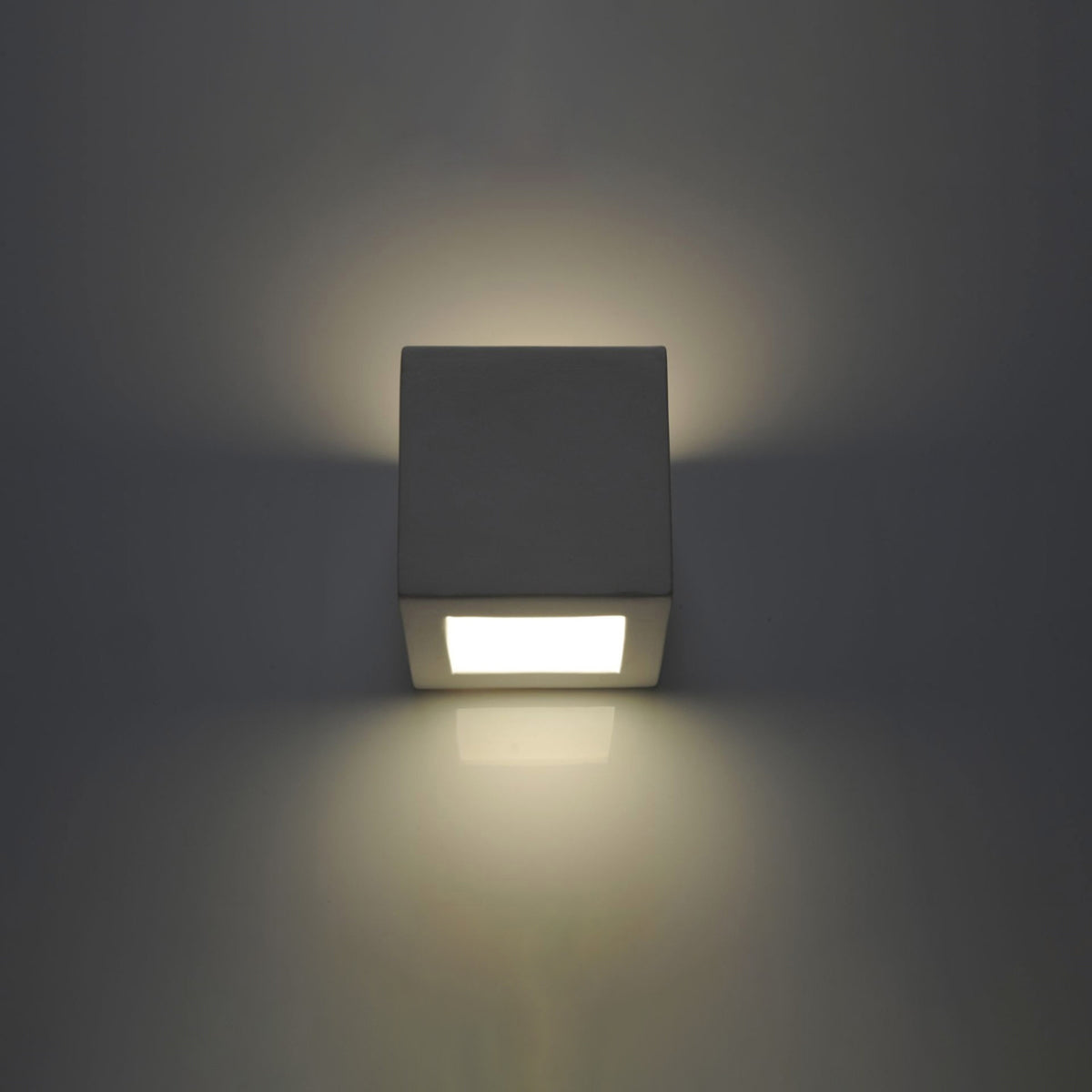 Même applique murale en ambiance sombre, halo lumineux diffusé autour du boîtier