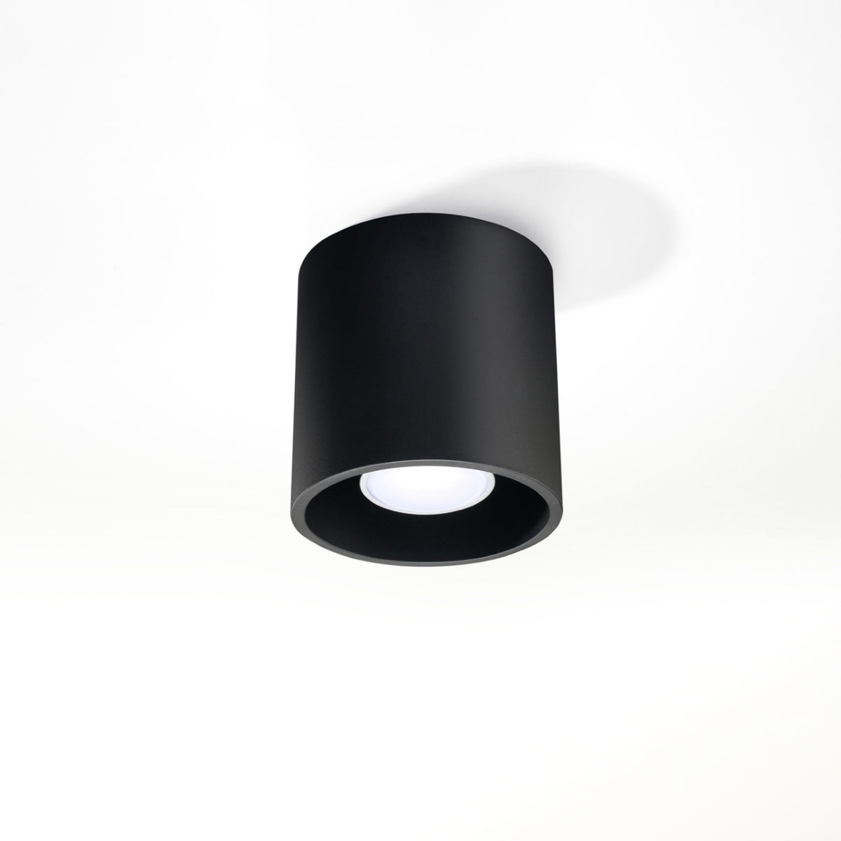 Plafonnier noir installé au plafond blanc, éclairage éteint, vu de trois quarts.