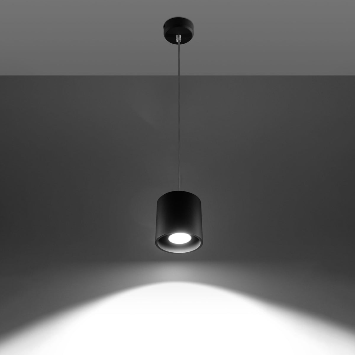 Mise en ambiance sombre avec la lampe allumée projetant un halo lumineux.