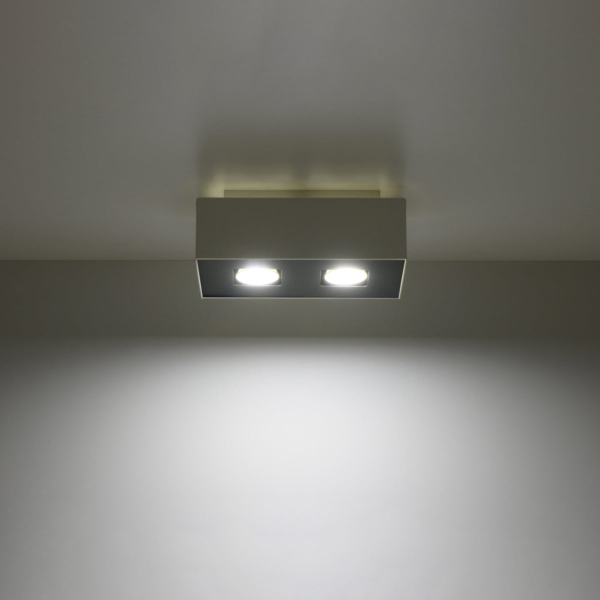 Plafonnier allumé au plafond, deux faisceaux lumineux projetés vers le bas